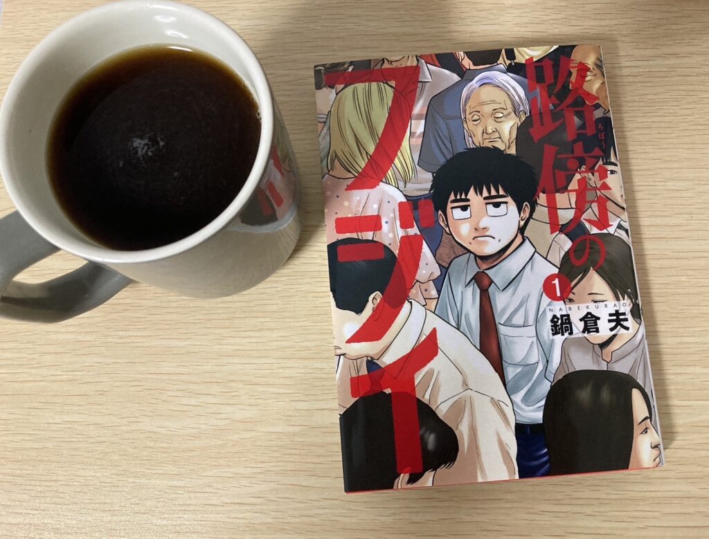 コーヒーの横に置かれた「路傍のフジイ」の単行本の写真画像